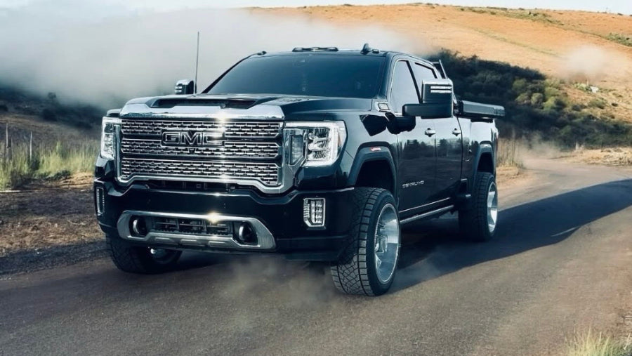 Black truck driving on a road with 'Alter Ego Diesel Performance' logo.